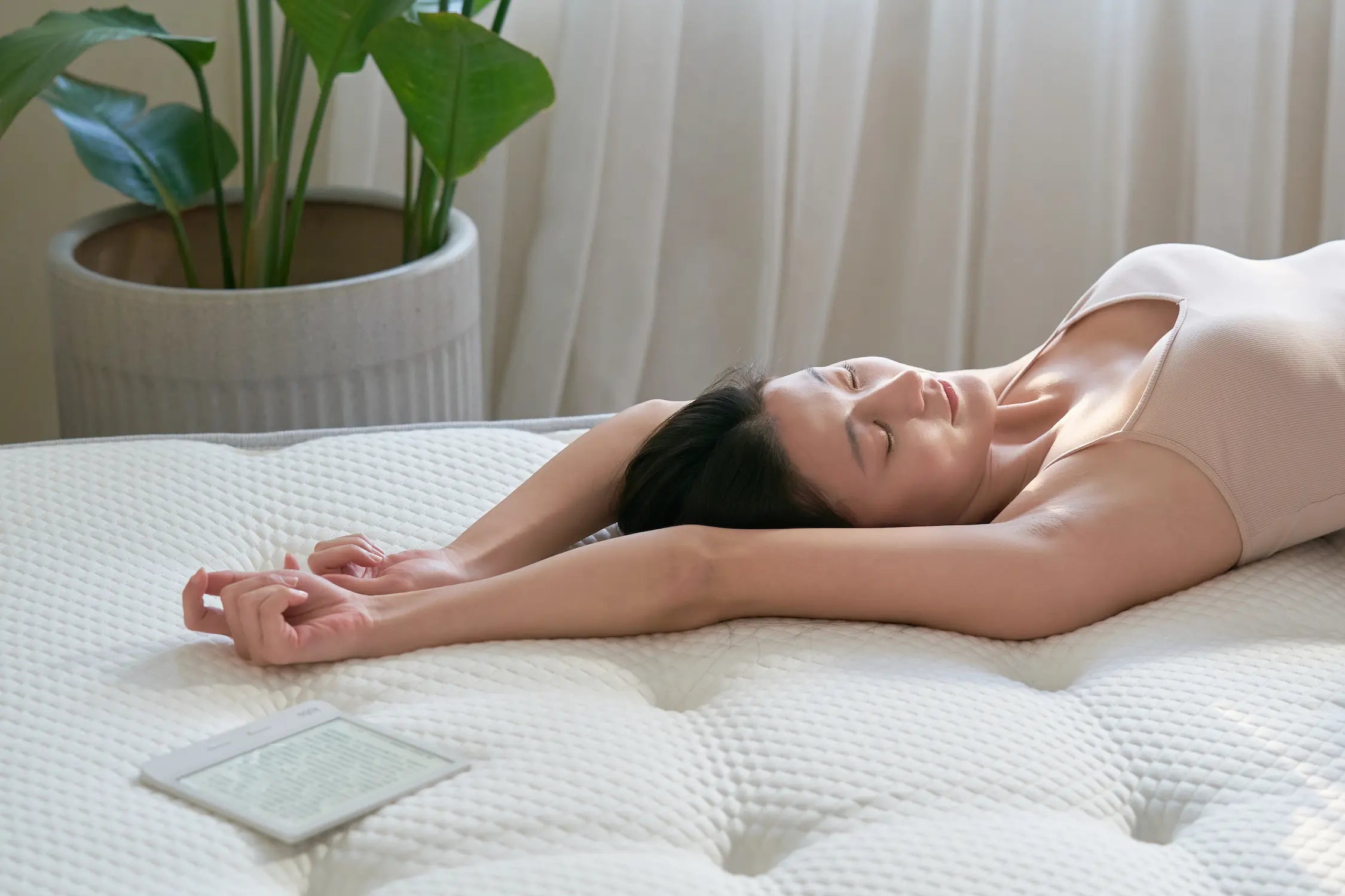 使用者仰躺於 Original 2.3 經典好眠床墊上,雙手伸展於頭上,畫面呈現天絲絎縫表布的立體紋理與床墊貼合支撐性,營造自然光下的放鬆氛圍。