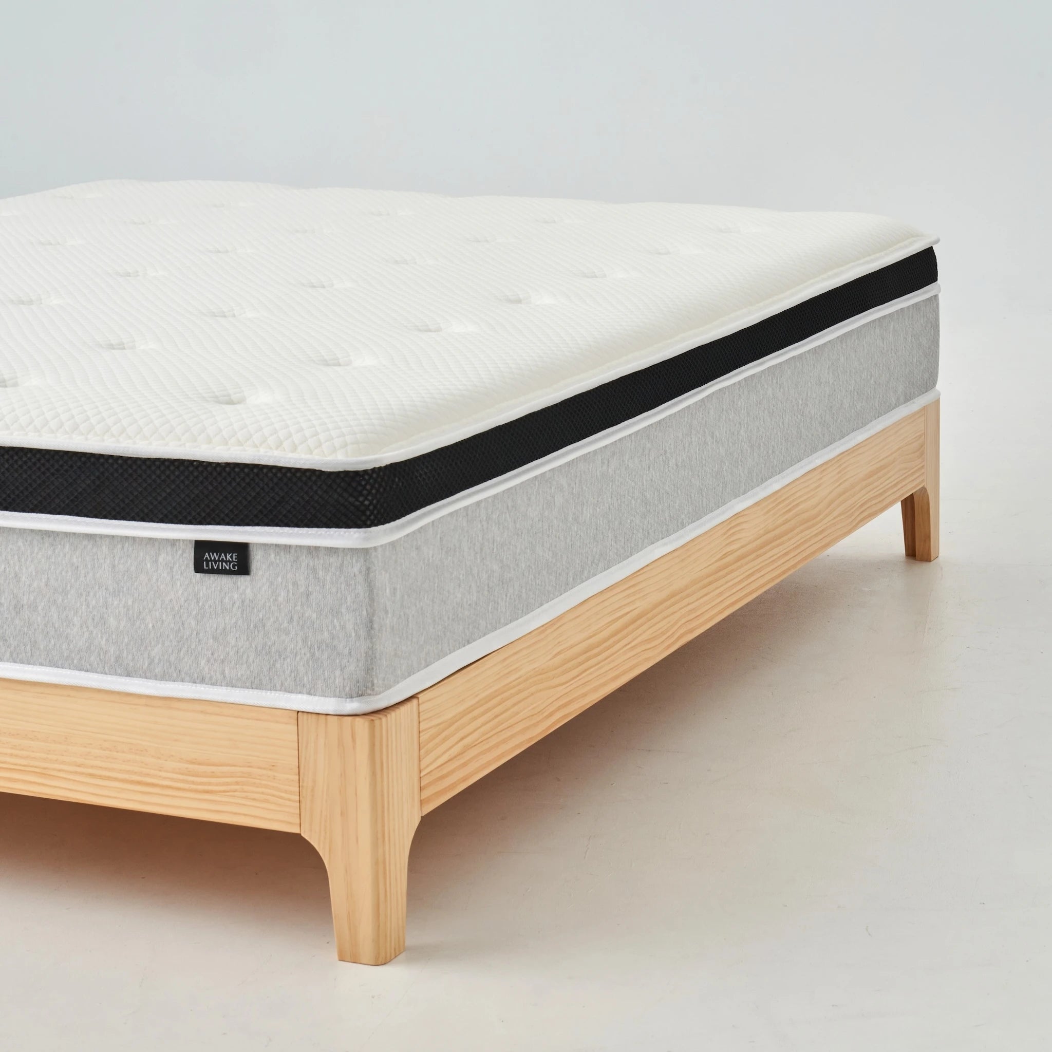 Rigid 2.4 床墊置於淺色木質床架上的斜角視圖。