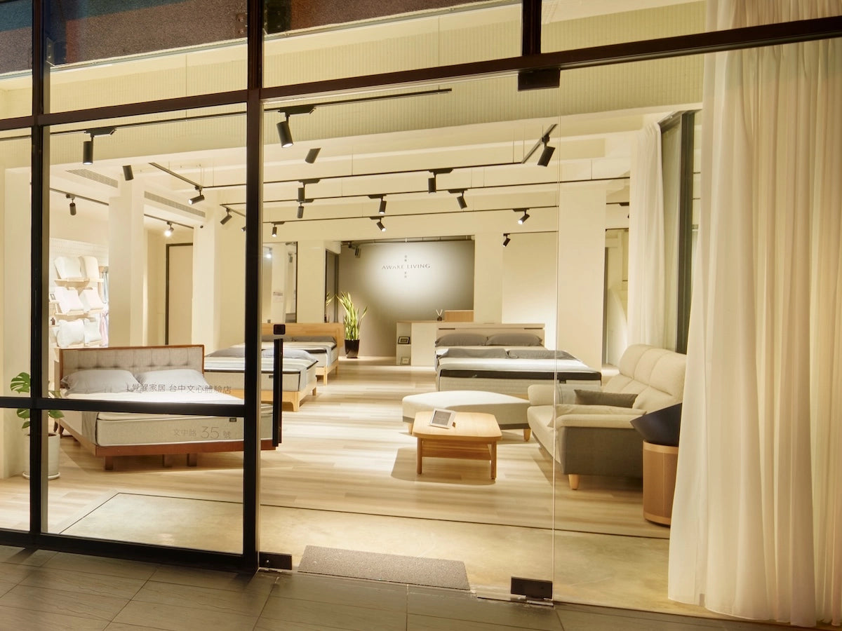 Awake Living 台中文心體驗店門市的夜間全景,可從店外看見內部寬敞明亮的床墊展示區。