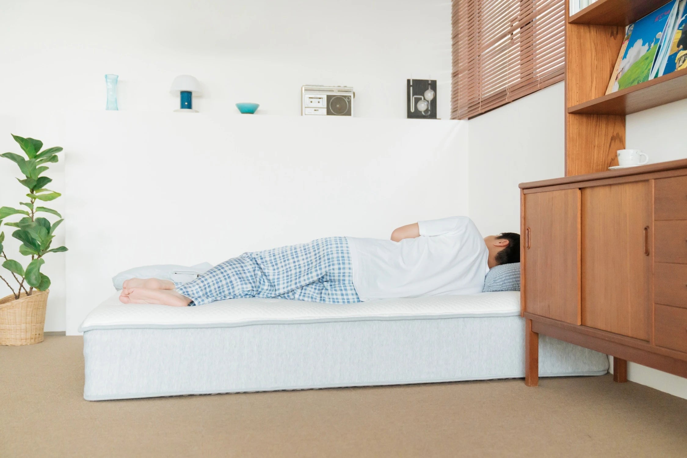 一位男子穿著睡衣,側躺在 Elite 2.0 床墊上睡覺。