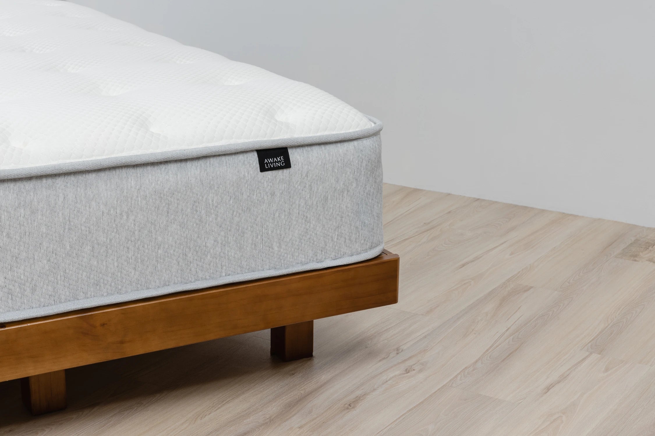 Elite 2.0 床墊置於木質床架上的角落細節圖。