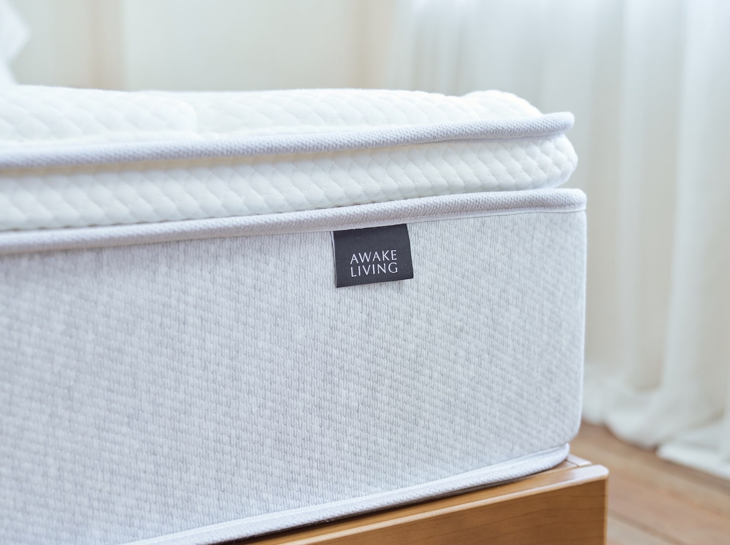 覺醒家居 Original 經典好眠床墊的一角,上方露出覺醒家居的標籤 Awake Living