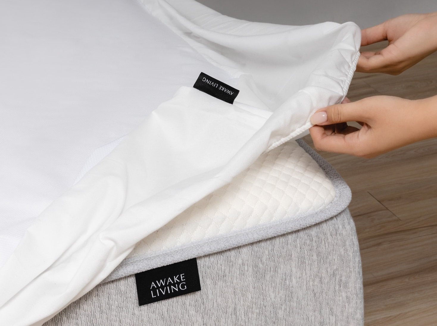 一雙手正在為覺醒家居的 Original 經典好眠套上覺醒家居的 3M 保潔墊