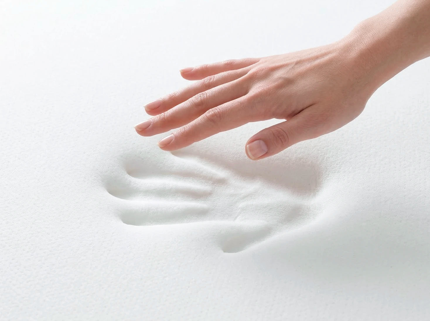 以手去按壓記憶棉呈現慢回彈特性，白色的記憶棉上殘存著尚未回彈的手印。