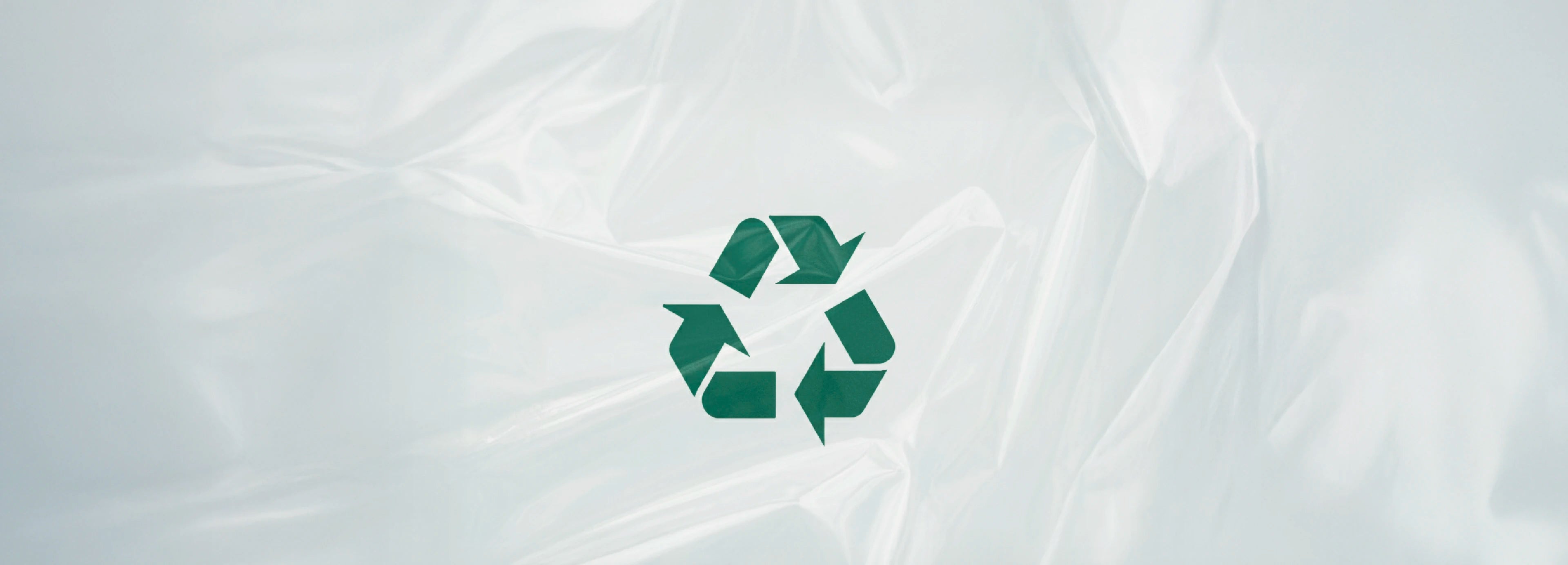 深綠色的國際通用回收標誌，位於一片呈現複雜皺褶紋理和光澤的半透明灰白色塑膠膜正中央，展示環保回收概念。