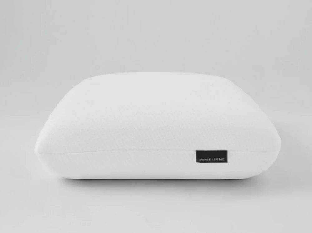 一顆純白的枕頭帶著 Awake Living 的黑色標籤放在畫面正中央